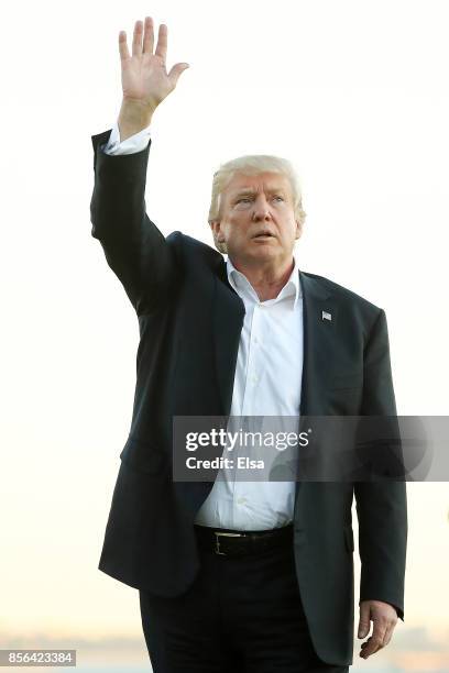 President Donald Trump waves after members of the U.S. Team defeated the International Team 19 to 11 in the Presidents Cup at Liberty National Golf...