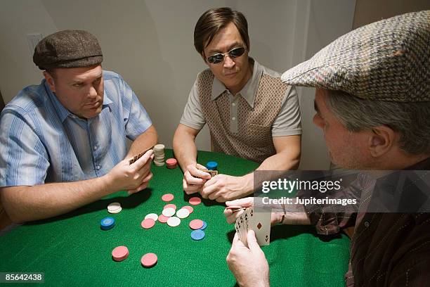 men playing poker together - volles haus stock-fotos und bilder