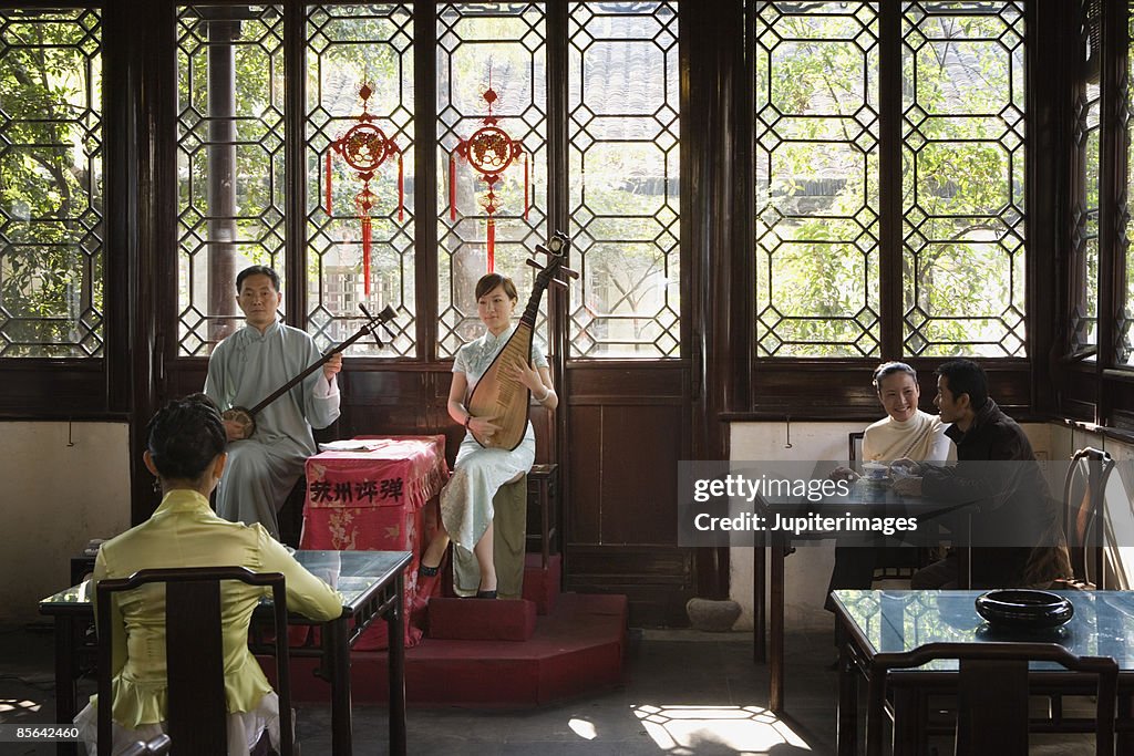 85642460 Man And Woman Playing Music In Teahouse Photo - Getty Images