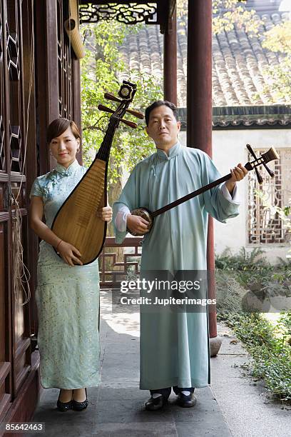 musicians holding traditional instruments - cheongsam stockfoto's en -beelden