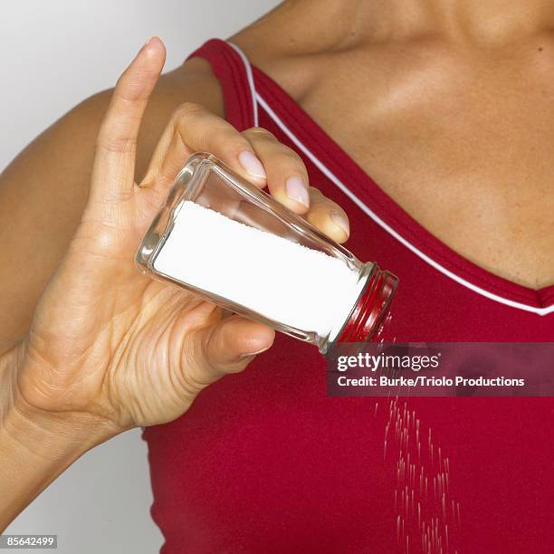 woman shaking saltshaker - saliera foto e immagini stock
