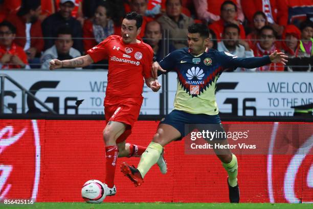 Rubens Sambueza of Toluca struggles for the ball with Silvio Romero of America during the 12th round match between Toluca and America as part of the...