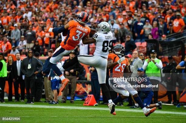 Strong safety Justin Simmons of the Denver Broncos intercepts a deep pass intended for wide receiver Amari Cooper of the Oakland Raiders as free...