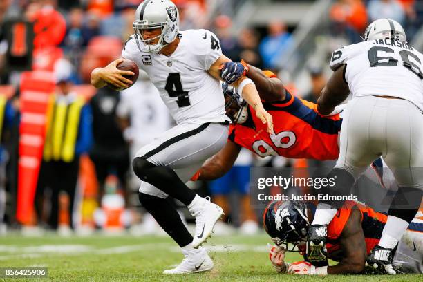 Quarterback Derek Carr of the Oakland Raiders tries to avoid a tackle by defensive end Shelby Harris of the Denver Broncos in the third quarter of a...