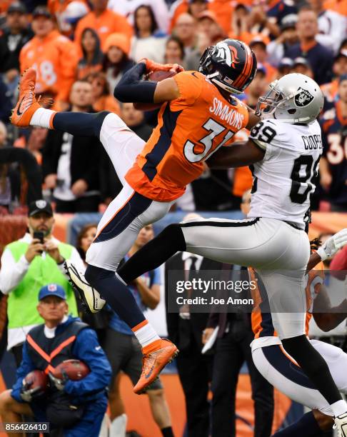 Justin Simmons of the Denver Broncos makes a game-clinching interception on a pass intended for Amari Cooper of the Oakland Raiders during the fourth...