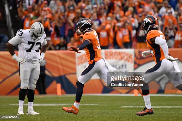 Justin Simmons of the Denver Broncos celebrates his game-clinching interception with teammate Will Parks as Marshall Newhouse of the Oakland Raiders...