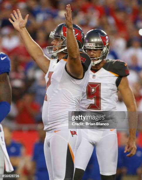 Kicker Nick Folk of the Tampa Bay Buccaneers celebrates as he and punter Bryan Anger watch the path of his 34-yard field goal to give the Buccaneers...