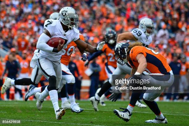 Punter Marquette King of the Oakland Raiders carries the ball on a fake punt play before being hit by tight end A.J. Derby of the Denver Broncos at...
