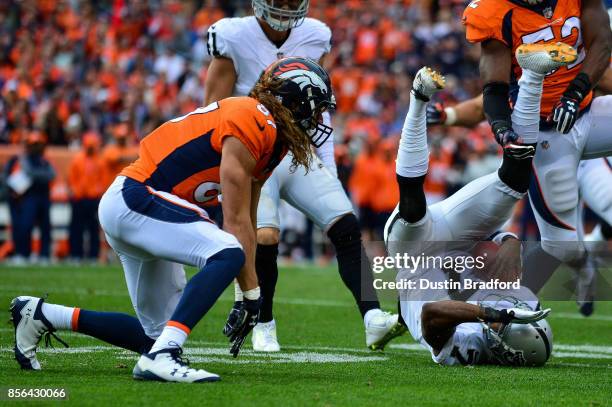 Punter Marquette King of the Oakland Raiders lies on the ground after being hit by tight end A.J. Derby of the Denver Broncos after a fake punt play...