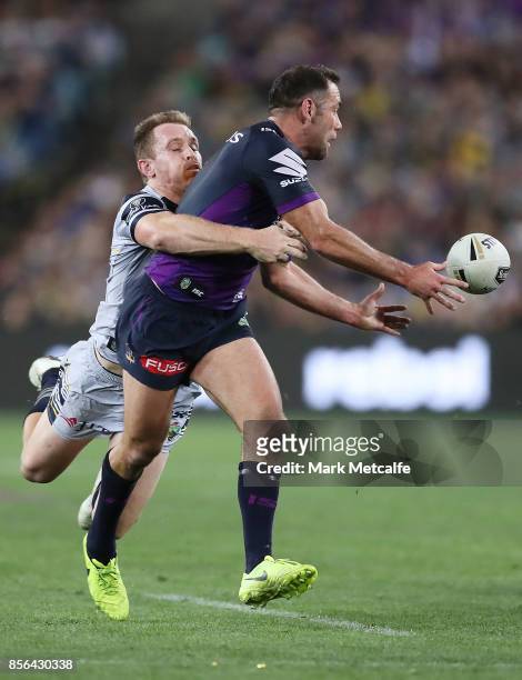 Cameron Smith of the Storm offloads as he is tackled by Michael Morgan of the Cowboys during the 2017 NRL Grand Final match between the Melbourne...