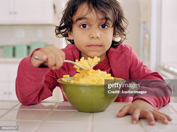 boy eating macaroni and cheese - mac and cheese stock pictures, royalty-free photos & images