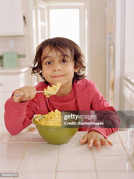 boy eating macaroni and cheese - macaroni and cheese stock pictures, royalty-free photos & images