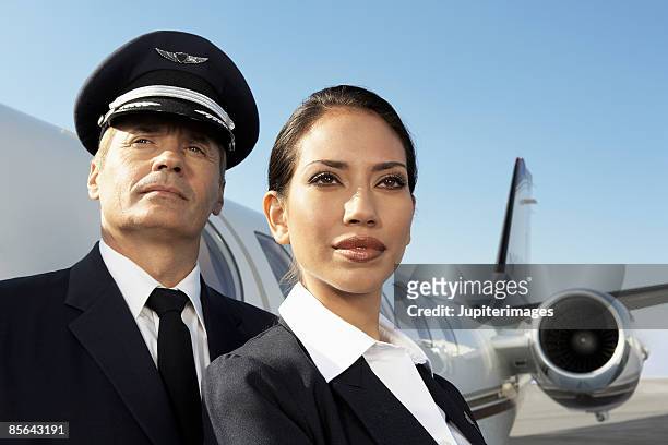pilot and flight attendant with airplane - air stewardess stock pictures, royalty-free photos & images