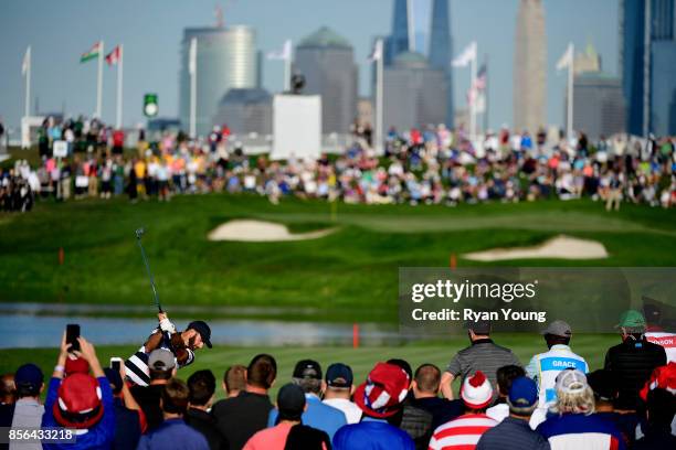 Dustin Johnson of the U.S. Team hits a shot on 18 during the Sunday singles matches at the Presidents Cup at Liberty National Golf Club on October 1...