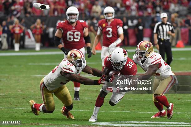 Running back Andre Ellington of the Arizona Cardinals is hit by middle linebacker NaVorro Bowman of the San Francisco 49ers and cornerback Jimmie...