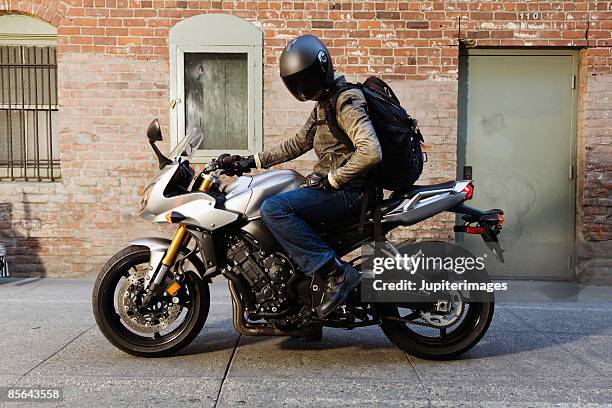 man wearing helmet on motorcycle - motocicletta foto e immagini stock