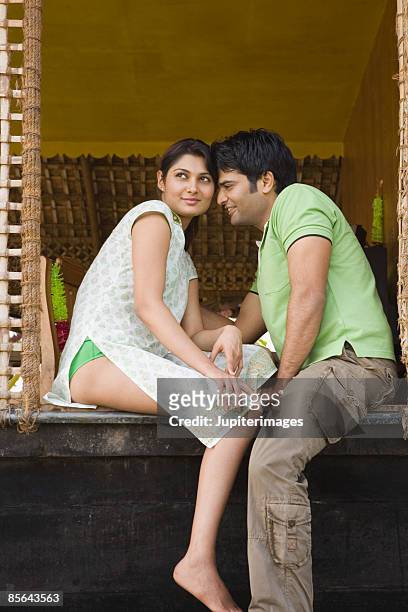 couple sitting together on edge of houseboat, india - daily life in kerala stock-fotos und bilder