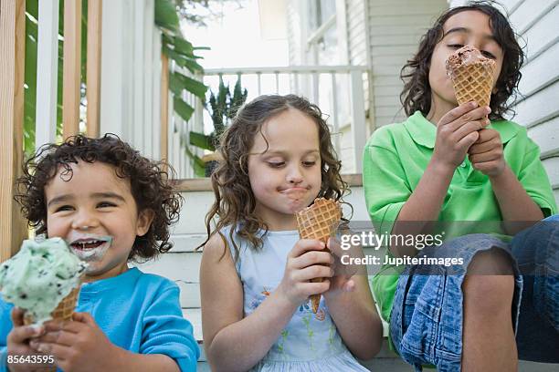 children eating ice cream cones - girl eating messy ice cream cone stock pictures, royalty-free photos & images