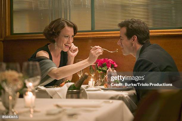 woman feeding man in restaurant - fancy meal stock pictures, royalty-free photos & images
