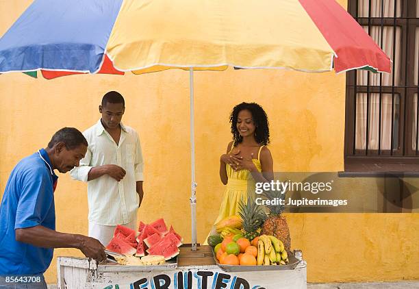 couple and vendor at fruit cart , cartagena , colombia - cartagena colombia stock pictures, royalty-free photos & images