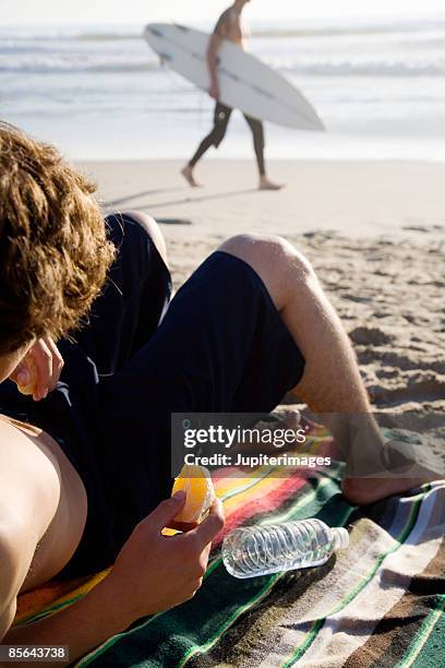 Bot Sunbaking Teen Boy On Beach Holding Orange High-Res Stock Photo - Getty Images