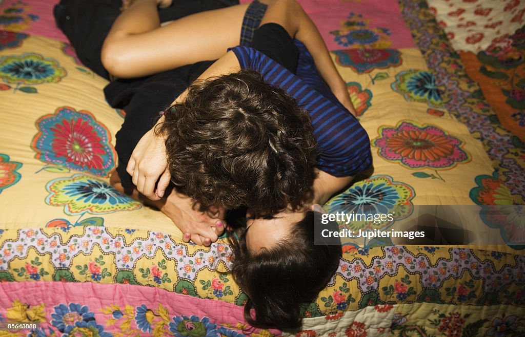 Teenage couple kissing on bed