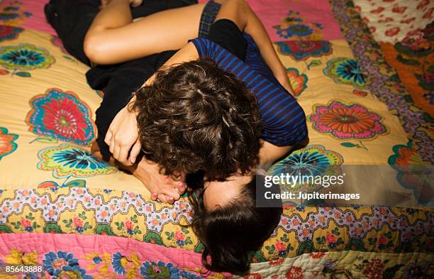 teenage couple kissing on bed - couple cuddling in bed stock pictures, royalty-free photos & images