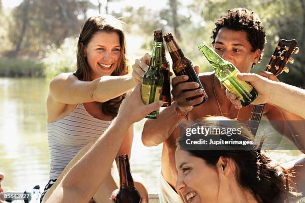 friends toasting with beer - bierfles stockfoto's en -beelden
