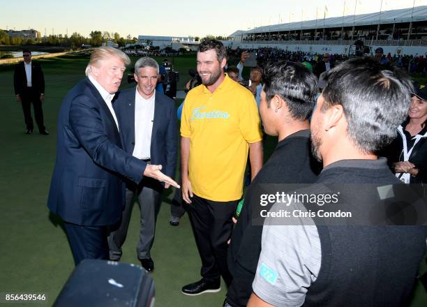 President Donald Trump shakes hands with Hideki Matsuyama of Japan and the International Team as Marc Leishman looks on after the U.S. Team defeated...