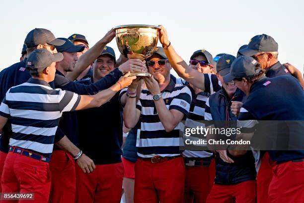 Members of the U.S. Team celebrate with the trophy after they defeated the International Team 19 to 11 in the Presidents Cup at Liberty National Golf...