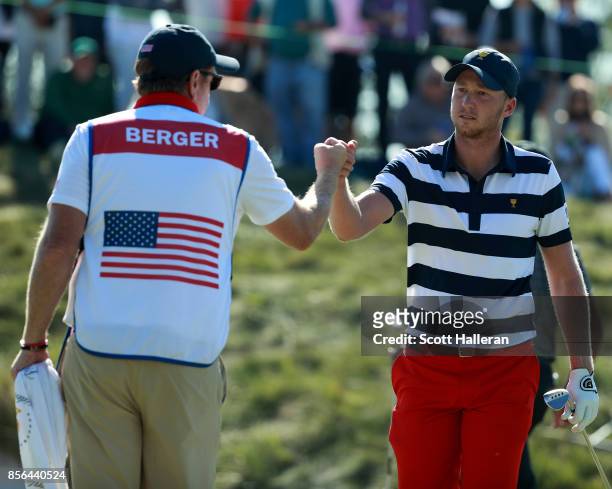 Daniel Berger of the U.S. Team fist pumps his caddie during the Sunday singles matches at the Presidents Cup at Liberty National Golf Club on October...