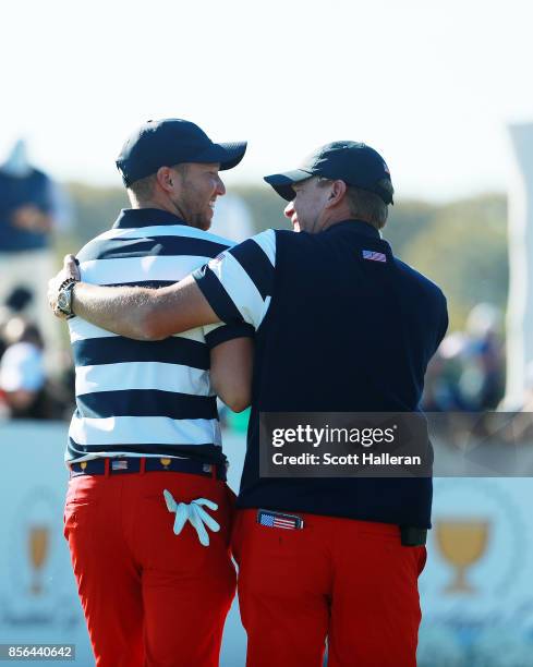 Steve Stricker, Captain of the U.S. Team, congratulates Daniel Berger of the U.S. Team after clinching the win for the U.S. Team during the Sunday...