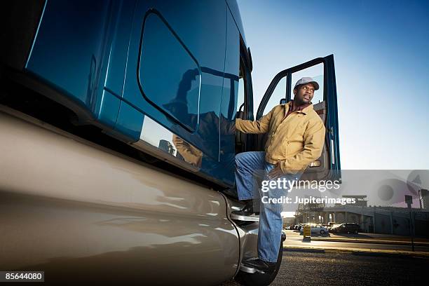 trucker stepping into tractor trailer - black lorry stock pictures, royalty-free photos & images