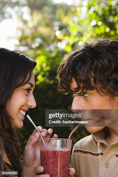 teen boy and girl sharing fruit smoothie - pojkvän bildbanksfoton och bilder