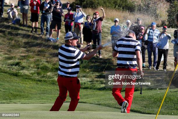 Golfer Charley Hoffman sprays Daniel Berger with champagne on the 17th hole after USA clinches winning the Presidents Cup during the final round of...