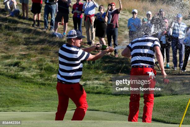 Golfer Charley Hoffman sprays Daniel Berger with champagne on the 17th hole after USA clinches winning the Presidents Cup during the final round of...