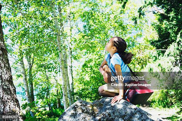 girl kneeling on rock - black girls rock stock-fotos und bilder