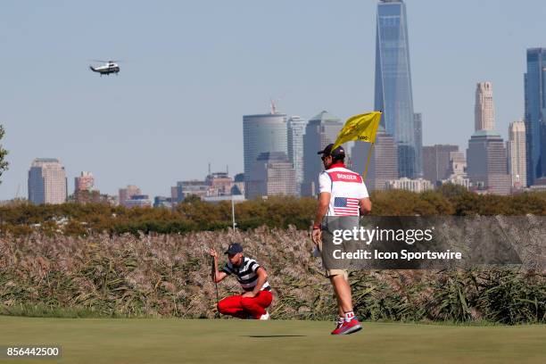 Golfer Daniel Berger putts on the 10th hole as the presidential helicopter flies over the Manhattan skyline as Donald Trump the 45th president of the...