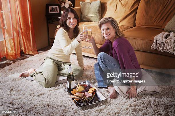 two women toasting with champagne - cheese and champagne stock pictures, royalty-free photos & images
