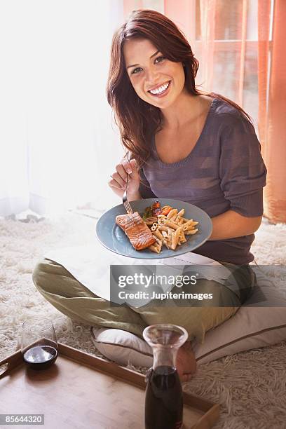 smiling woman eating healthy meal - whole wheat penne pasta stock pictures, royalty-free photos & images