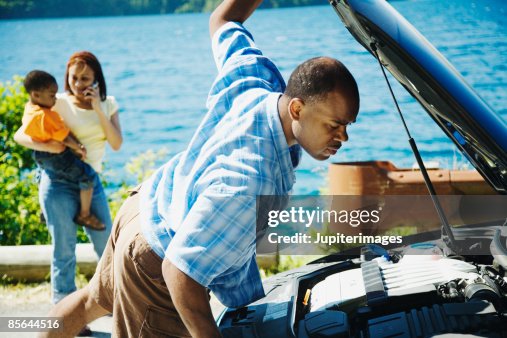 Man looking under hood Man looking under hood