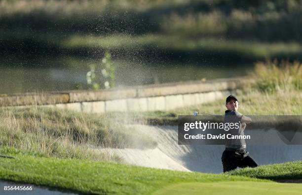 Emiliano Grillo of Argentina and the International team plays his second shot at the 14th hole in his match against Rickie Fowler during the final...