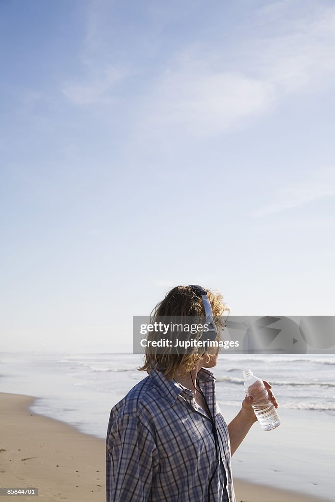 Teen Boy On Beach Holding Water Bottle High-Res Stock Photo - Getty Images