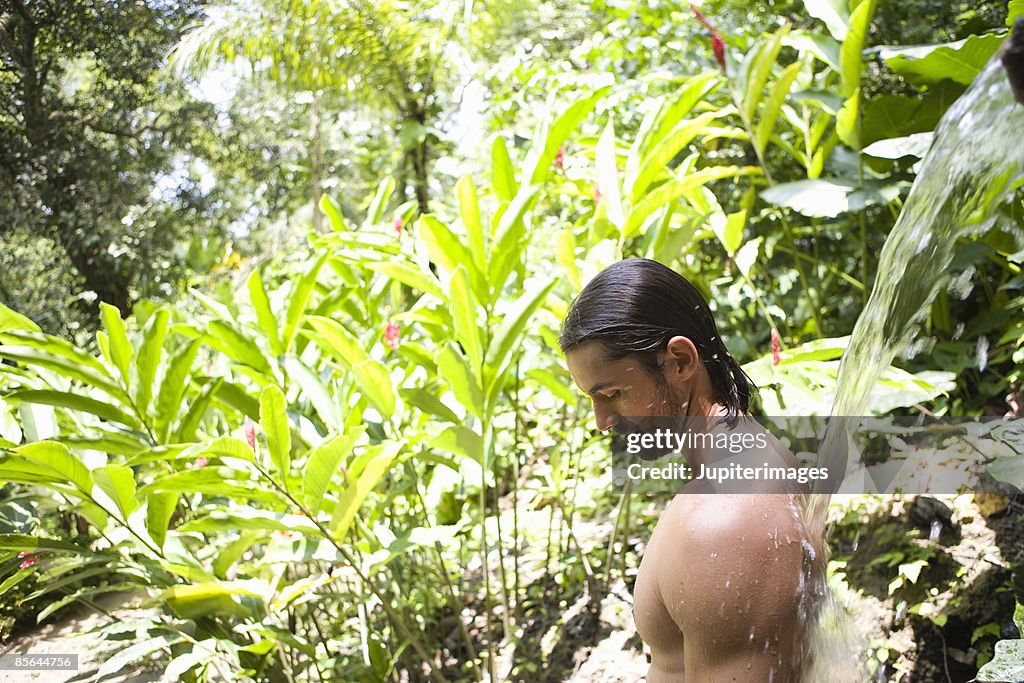 Man showering in tropical garden