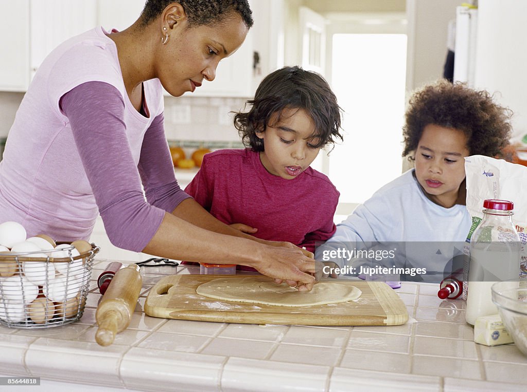 Woman and boys baking cookies