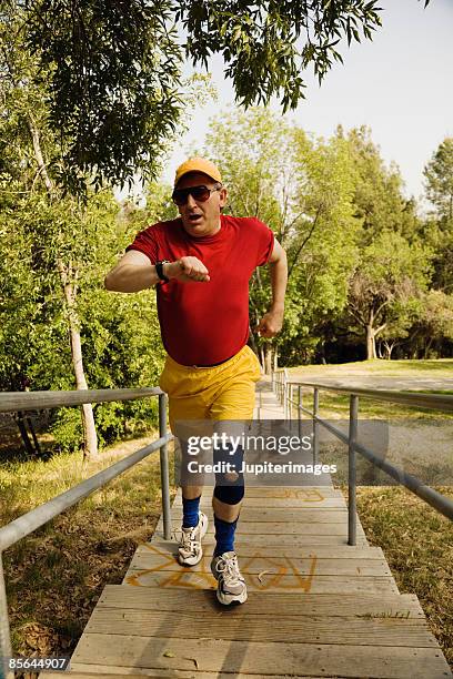 man running and looking at watch - knee brace stock pictures, royalty-free photos & images