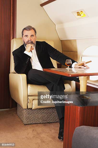 businessman in private airplane - cigar stock-fotos und bilder