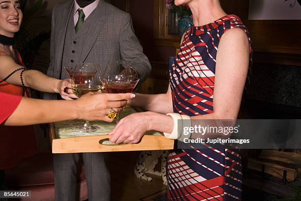 woman serving cocktails at party - cocktail ring stock-fotos und bilder