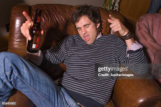 man drinking beer at party - beer bottle mouth stock-fotos und bilder