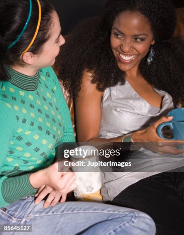Two friends laughing and drinking coffee Two friends laughing and drinking coffee
